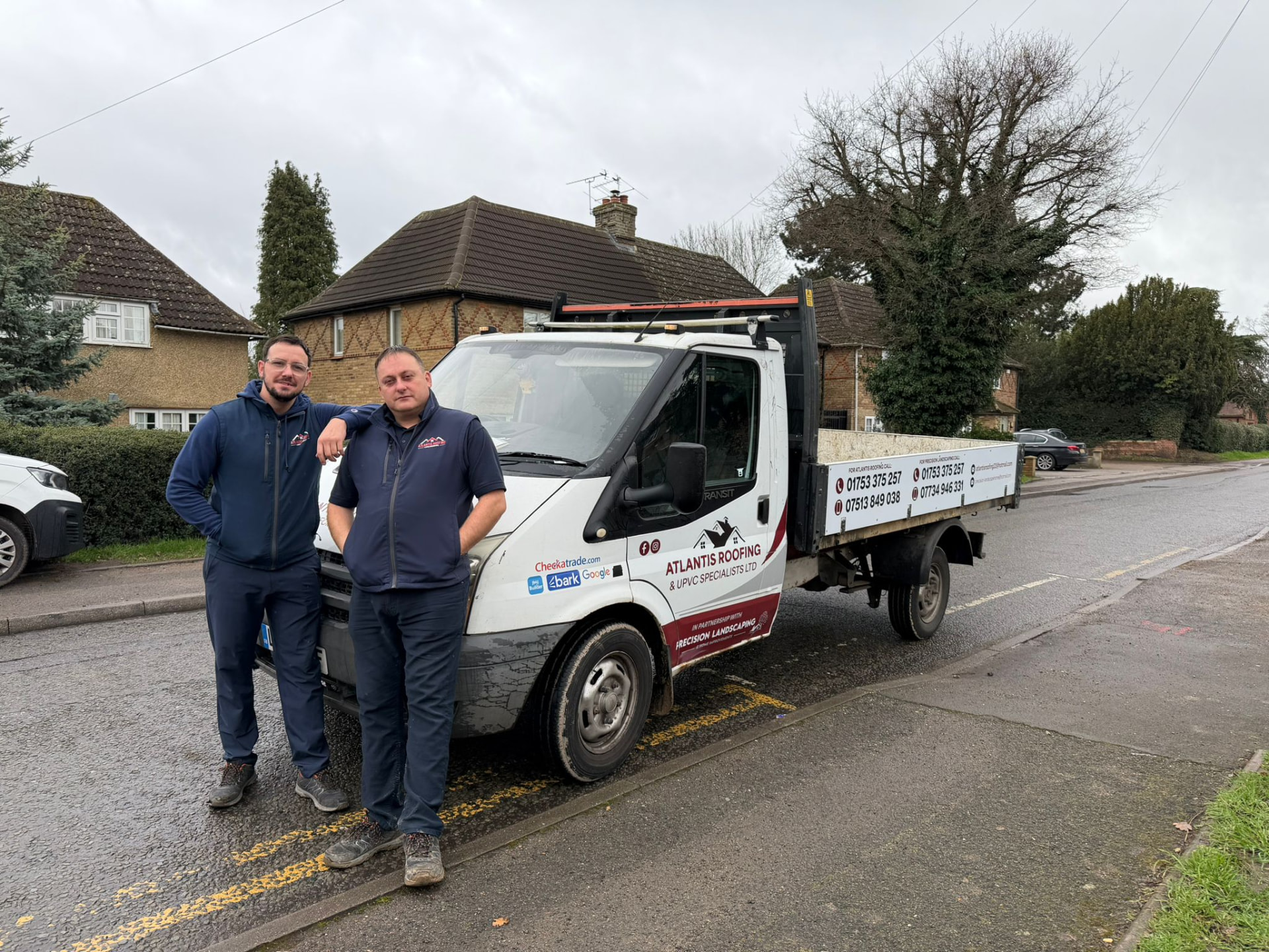 Atlantis Roofing team beside their branded tipper truck